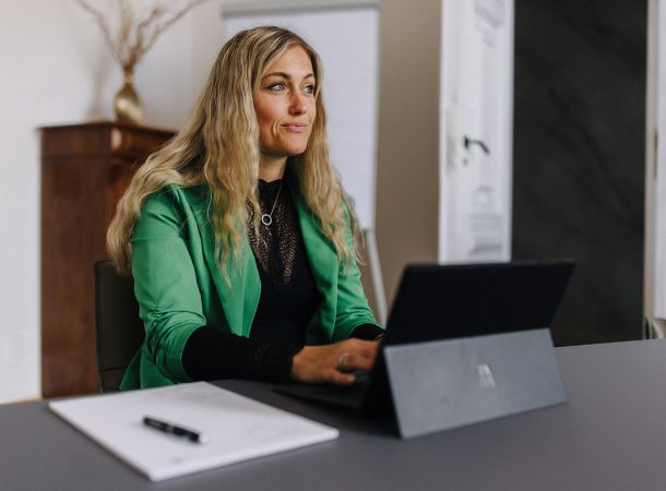 Mitarbeiterin der Steuerkanzlei arbeitet konzentriert am Laptop im Besprechungsraum