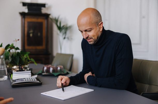 Steuerberater überprüft Unterlagen sorgfältig im Arbeitszimmer der Kanzlei